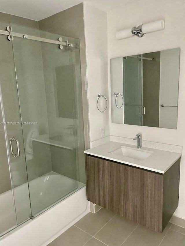 bathroom featuring vanity, combined bath / shower with glass door, and tile patterned floors