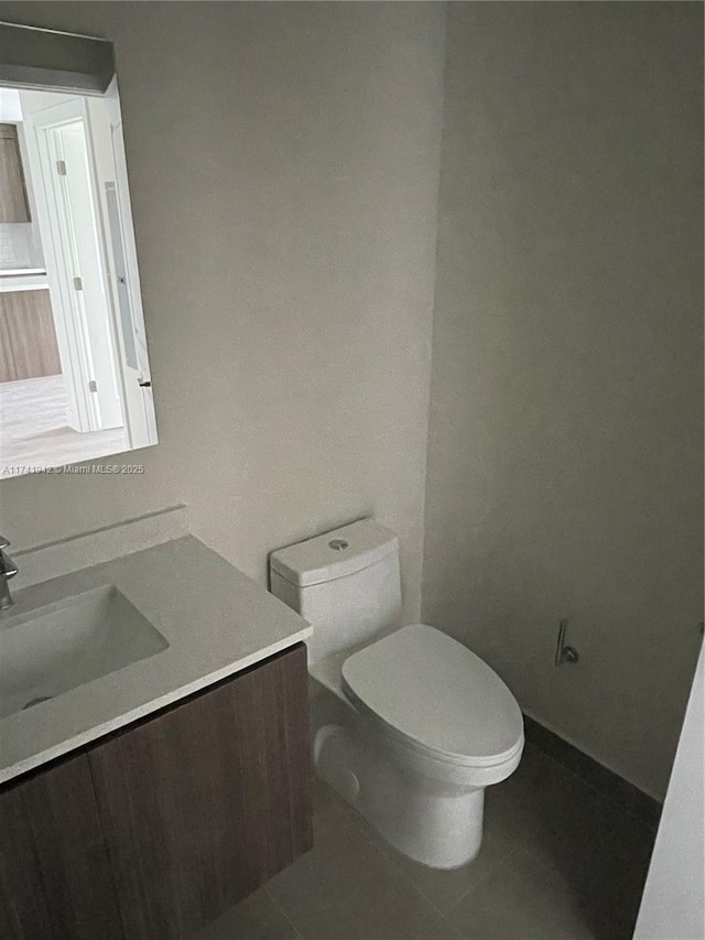 bathroom featuring tile patterned flooring, vanity, and toilet