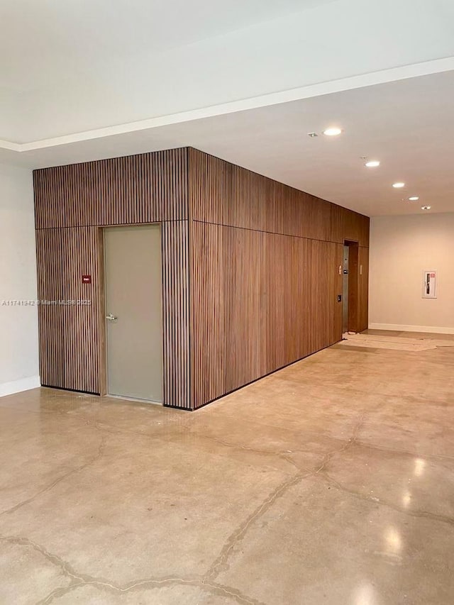 unfurnished room featuring wood walls