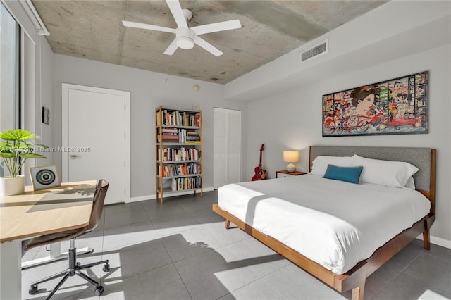 bedroom with ceiling fan, tile patterned floors, and a closet