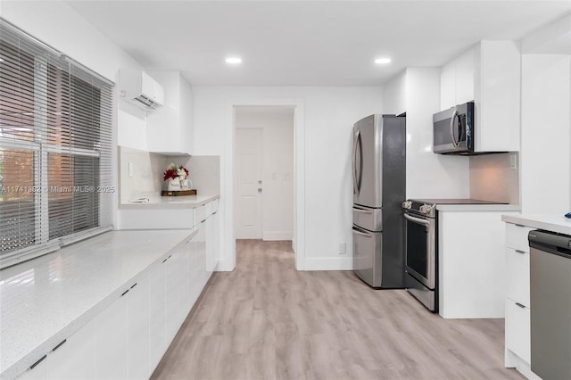 658 SW 1st Ct, Boynton Beach, FL 33426 - kitchen with stainless steel appliances, a wall mounted air conditioner, modern cabinets, light wood-type flooring, and recessed lighting