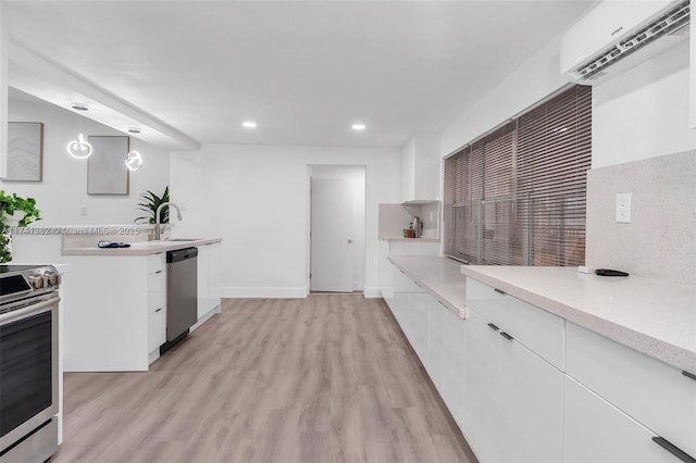 658 SW 1st Ct, Boynton Beach, FL 33426 - kitchen featuring appliances with stainless steel finishes, an AC wall unit, recessed lighting, white cabinets, and light wood finished floors
