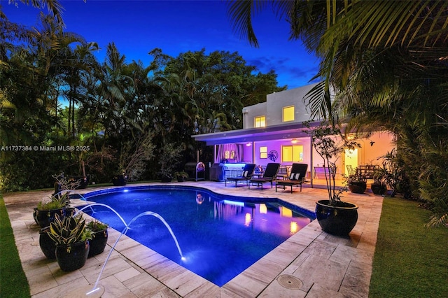 view of swimming pool featuring pool water feature and a patio area