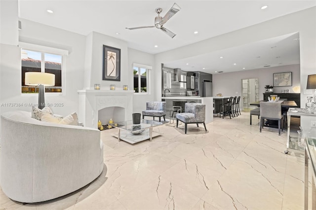 living room with sink, a wealth of natural light, and ceiling fan