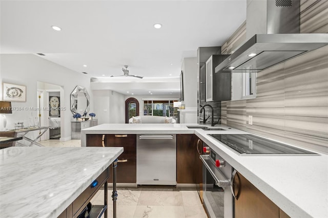 kitchen with dark brown cabinetry, wall chimney exhaust hood, black electric stovetop, oven, and decorative backsplash