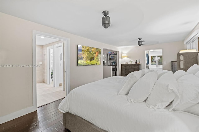 bedroom featuring a walk in closet and dark hardwood / wood-style flooring