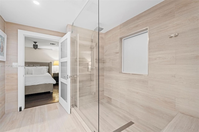 bathroom featuring hardwood / wood-style floors and a tile shower