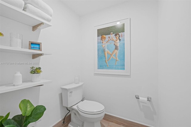 bathroom with hardwood / wood-style flooring and toilet