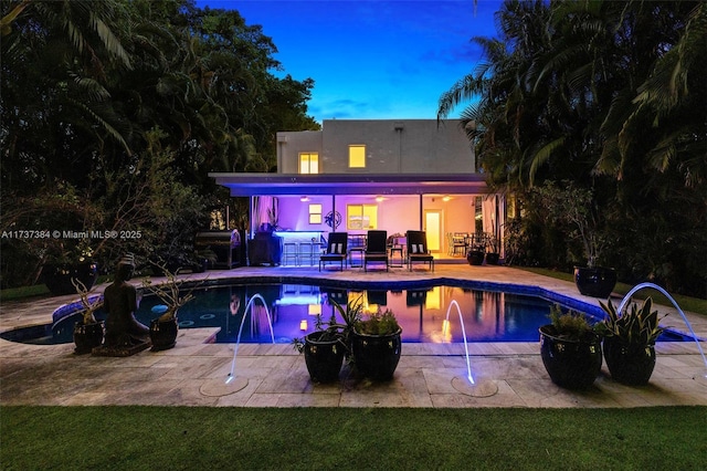 pool at dusk with a patio