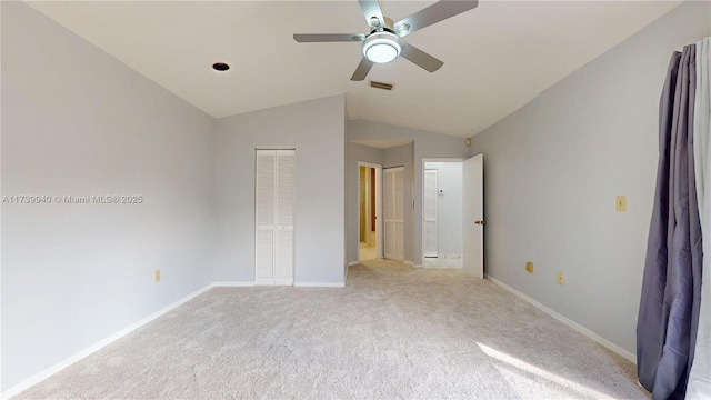 unfurnished bedroom with ceiling fan, ensuite bath, vaulted ceiling, and light carpet