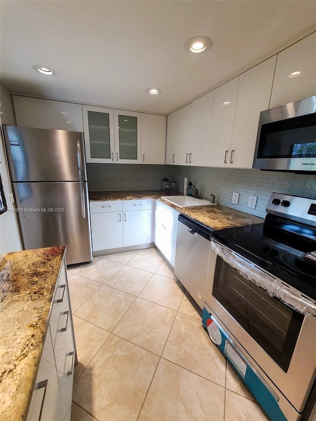 kitchen featuring white cabinetry, a sink, backsplash, and appliances with stainless steel finishes