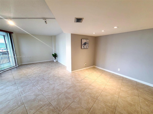 empty room featuring visible vents, baseboards, track lighting, light tile patterned floors, and recessed lighting
