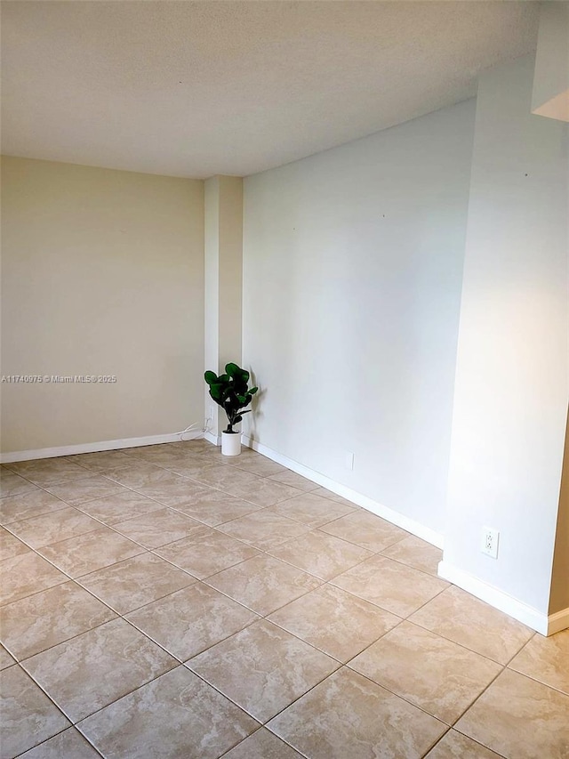 unfurnished room featuring light tile patterned floors and baseboards