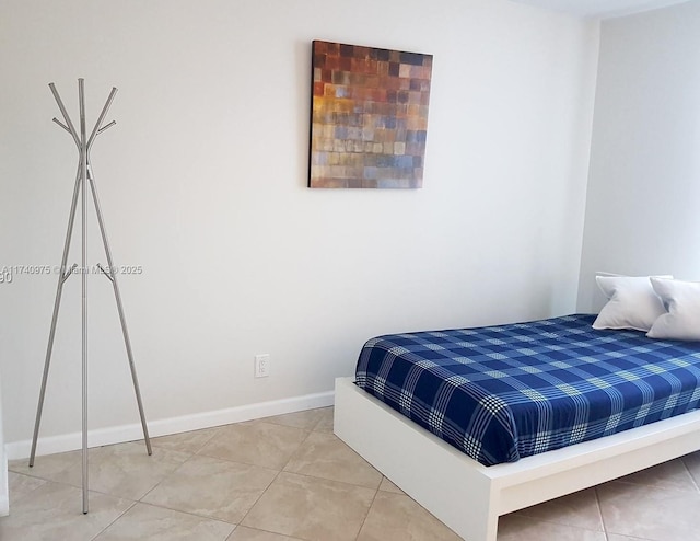 bedroom featuring light tile patterned floors and baseboards