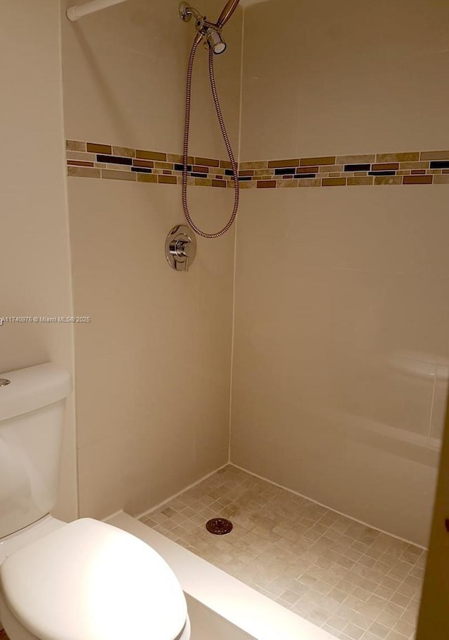 bathroom featuring toilet and a stall shower