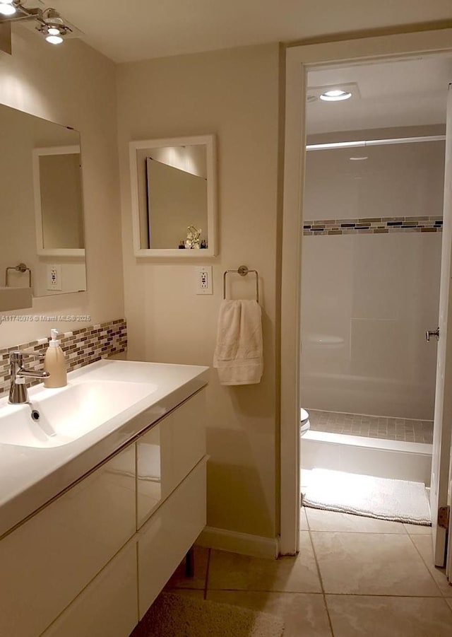 full bathroom featuring toilet, a shower stall, vanity, backsplash, and tile patterned floors