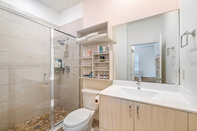 bathroom featuring vanity, toilet, and an enclosed shower