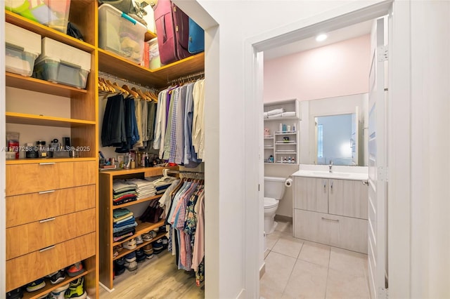 spacious closet featuring light tile patterned floors and sink