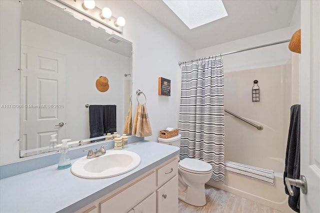 full bathroom with toilet, wood-type flooring, a skylight, shower / tub combo, and vanity