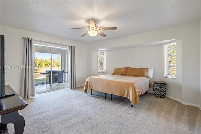 carpeted bedroom with ceiling fan, access to outside, and a textured ceiling