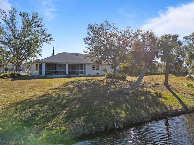 rear view of house featuring a water view and a yard