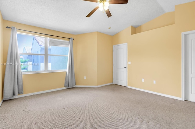 carpeted spare room featuring ceiling fan, baseboards, vaulted ceiling, and a textured ceiling