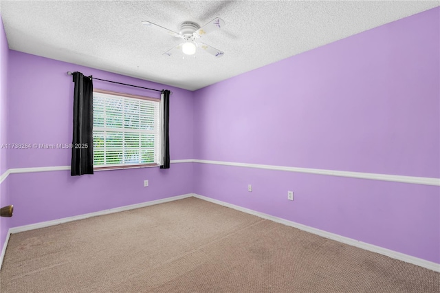 carpeted spare room with ceiling fan, baseboards, and a textured ceiling