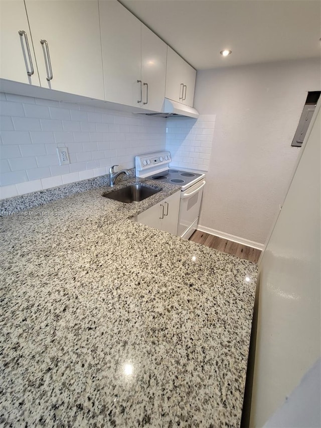 kitchen featuring sink, white cabinetry, electric range, light stone countertops, and backsplash