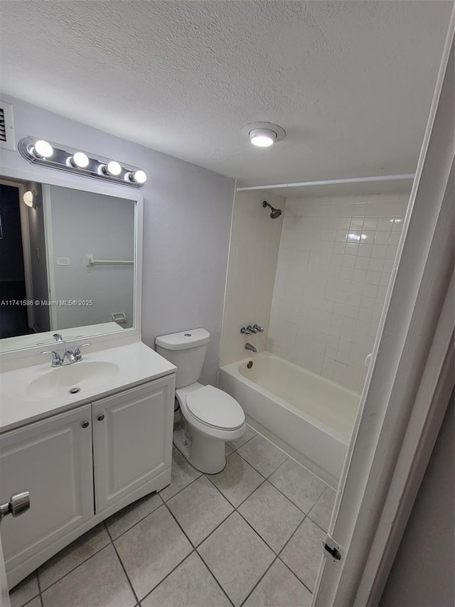 full bathroom featuring toilet, a textured ceiling, vanity, tiled shower / bath combo, and tile patterned flooring