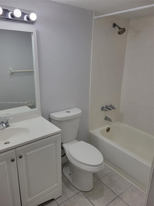 full bathroom featuring vanity, tile patterned flooring, toilet, and tiled shower / bath