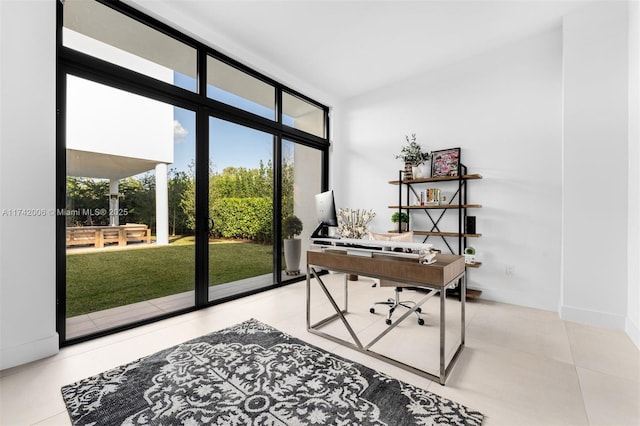 home office featuring lofted ceiling, expansive windows, and light tile patterned flooring