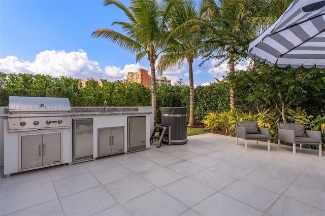 view of patio with area for grilling, a grill, and sink