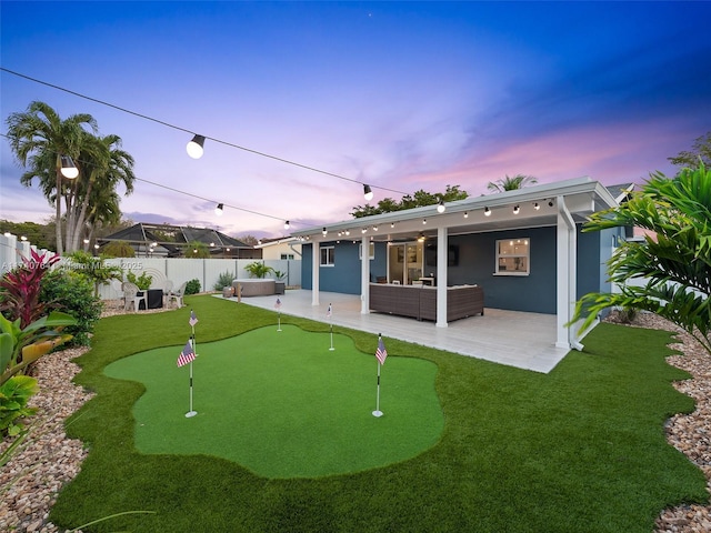 back house at dusk featuring an outdoor living space and a patio