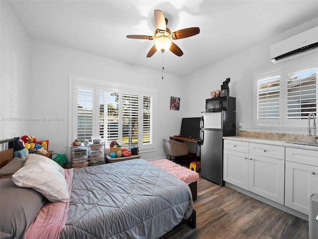 bedroom with dark wood-type flooring, sink, a wall mounted AC, stainless steel refrigerator, and ceiling fan