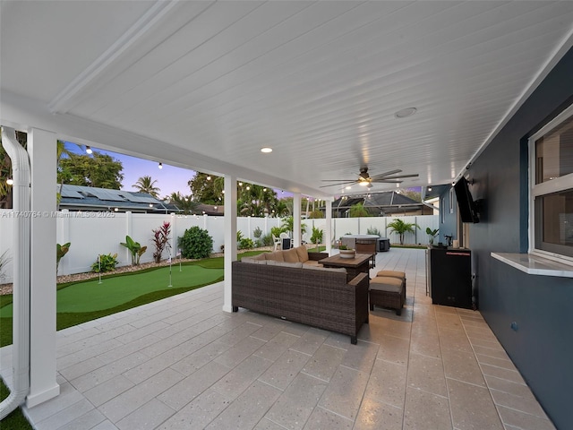 patio terrace at dusk with outdoor lounge area and ceiling fan