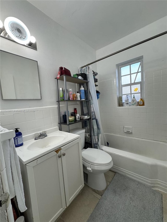 full bathroom featuring shower / bathtub combination with curtain, tile patterned flooring, tile walls, vanity, and toilet