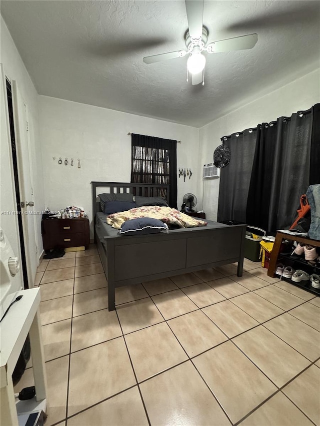 tiled bedroom with ceiling fan and a textured ceiling