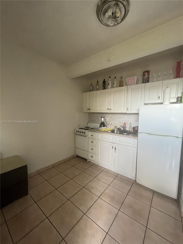 kitchen featuring light tile patterned floors, white cabinets, white appliances, and decorative backsplash