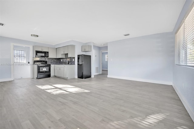 unfurnished living room with a wealth of natural light and light hardwood / wood-style flooring