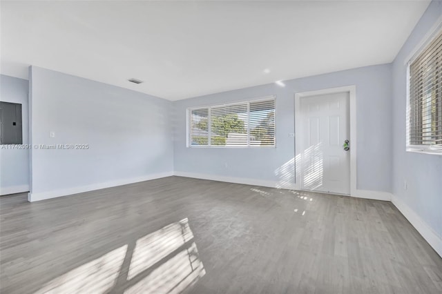 unfurnished room featuring electric panel and light hardwood / wood-style floors