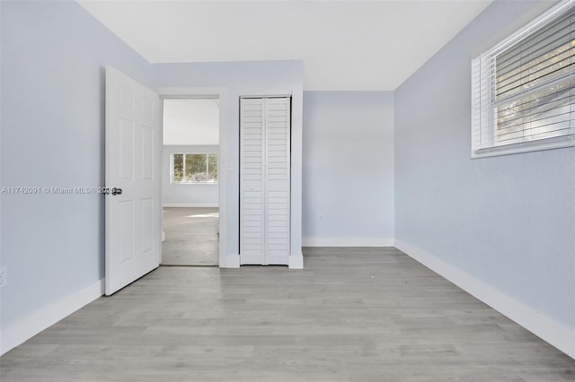 unfurnished bedroom featuring light hardwood / wood-style floors and a closet