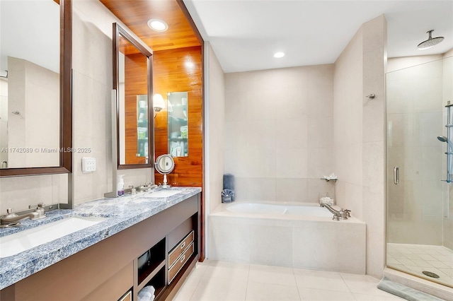 bathroom featuring tile walls, vanity, tile patterned floors, and plus walk in shower