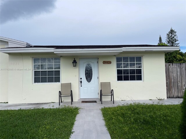 entrance to property featuring a lawn