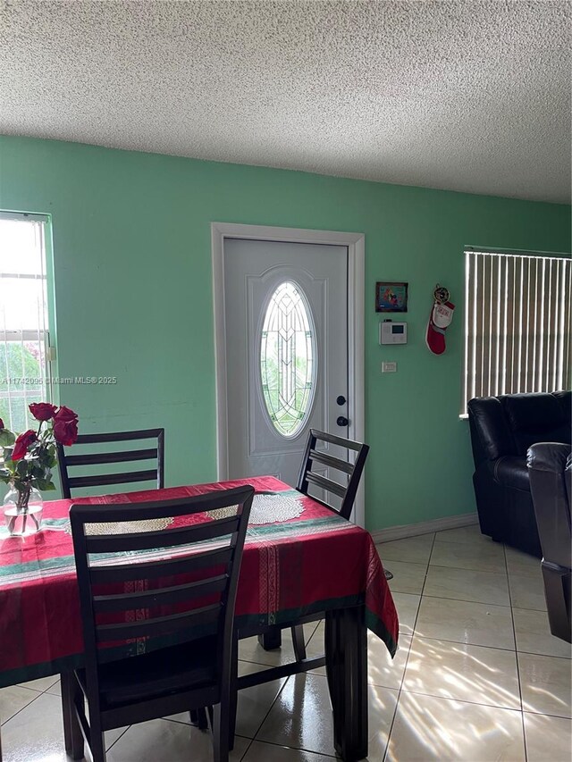 dining space with a textured ceiling and tile patterned flooring