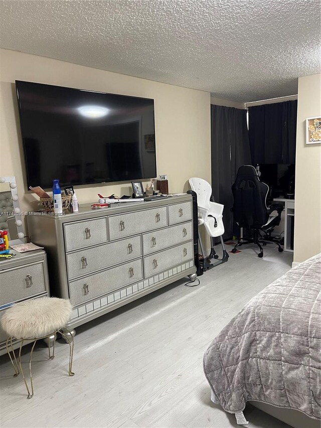 bedroom with light hardwood / wood-style flooring and a textured ceiling