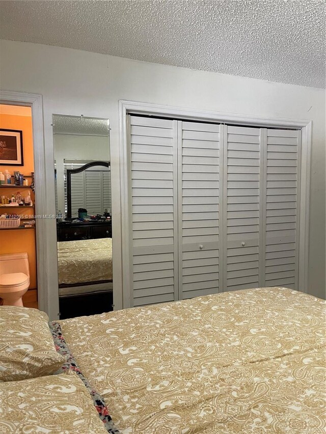 bedroom with a textured ceiling and a closet