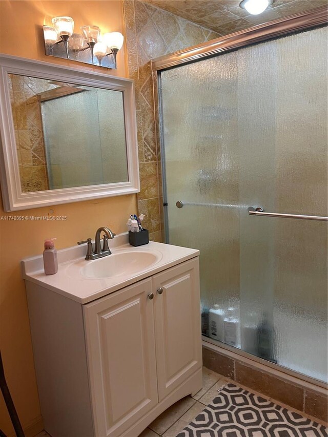 bathroom featuring walk in shower, tile patterned flooring, and vanity