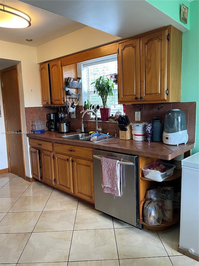 kitchen with tile counters, backsplash, light tile patterned floors, and dishwasher