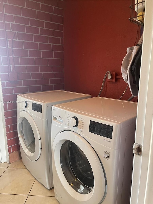 laundry area featuring light tile patterned floors and washing machine and clothes dryer