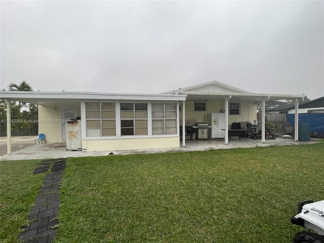 rear view of property with a lawn and a patio